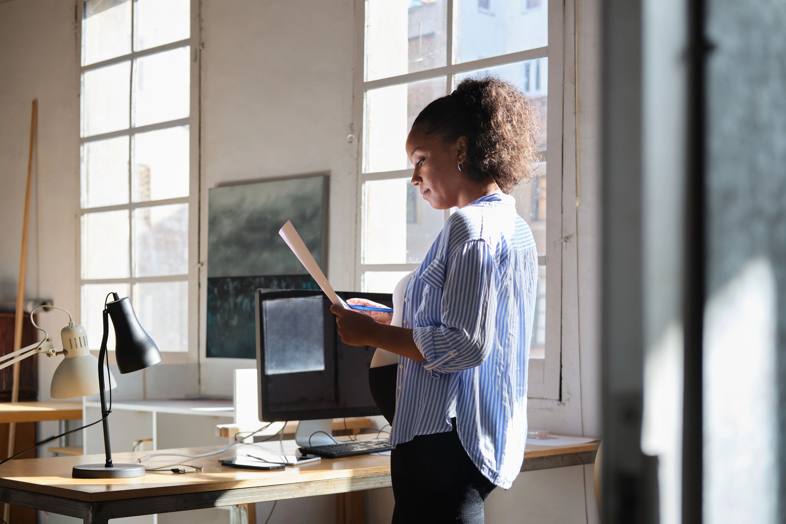 Woman reviewing notes and documents while planning her budget