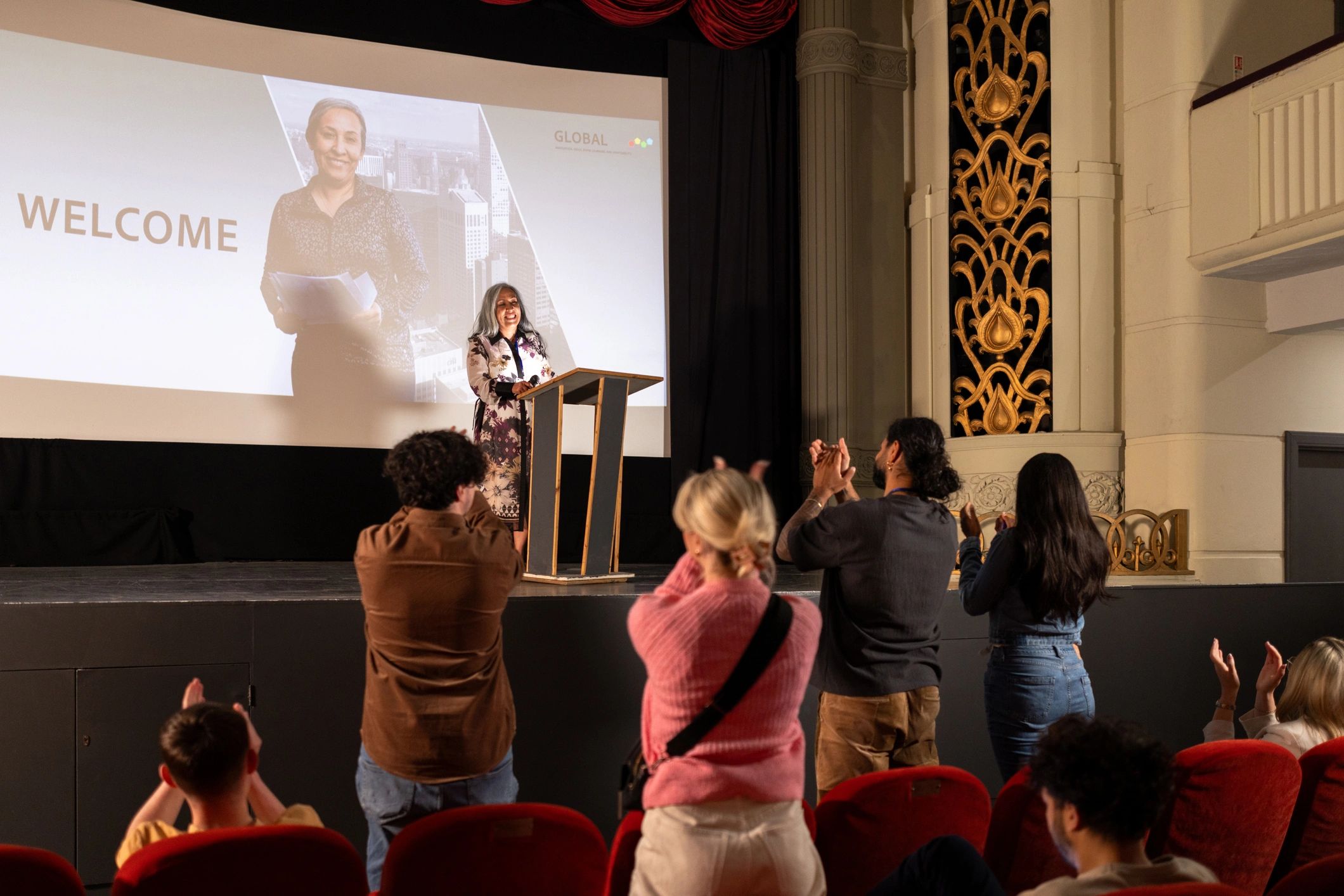 Speaker on stage engaging a conference audience